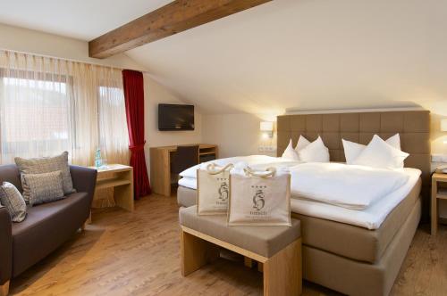 a hotel room with a large bed and a couch at Hotel Hirsch in Oberstaufen