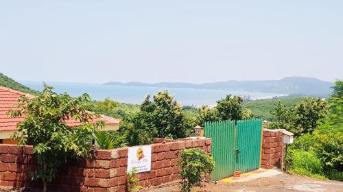 a brick wall with a green gate in the background at Redstone Hills, Diveagar in Diveagar