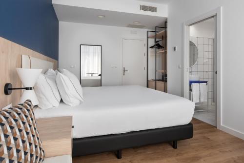 a bedroom with a large white bed with white pillows at Exe Vigo in Vigo