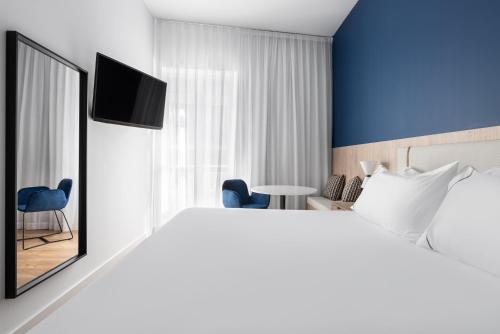 a hotel room with a large bed and a tv at Exe Vigo in Vigo