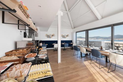 a restaurant with tables and chairs and large windows at Exe Vigo in Vigo