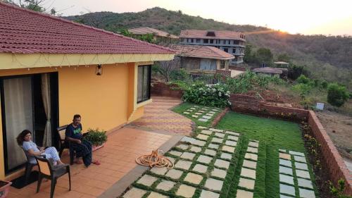 two women sitting on the porch of a house at Redstone Hills, Diveagar in Diveagar