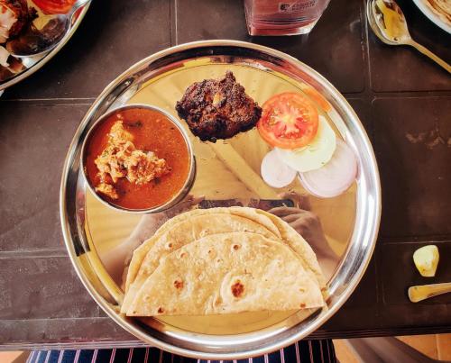 a plate of food with chapati and a plate of food at Redstone Hills, Diveagar in Diveagar