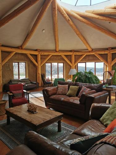 a living room with leather couches and a table at Lough Mardal Lodge in Donegal