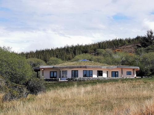 uma casa com um telhado de relva no topo de uma colina em Lough Mardal Lodge em Donegal