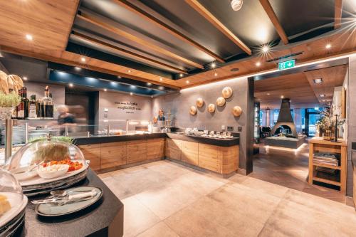 a large kitchen with a counter in a restaurant at ZillergrundRock Luxury Mountain Resort in Mayrhofen