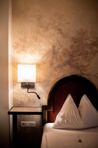 a bedroom with a bed and a lamp on a wall at Altstadt Hotel Stadtkrug in Salzburg