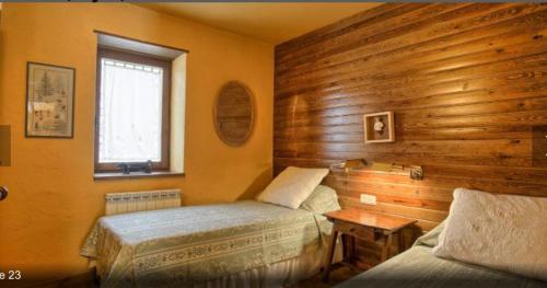 a bedroom with two beds and a window at Apartamento Rincon del cielo in Benasque