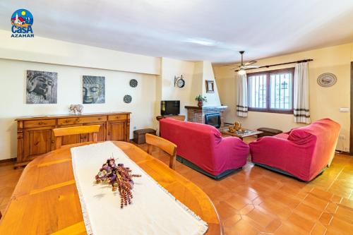 a living room with two red chairs and a table at Apartamentos Ibiza Casa Azahar in Alcossebre