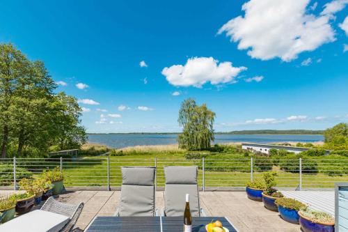 a patio with chairs and a view of the water at Haus am Schmollensee App 7i in Sellin