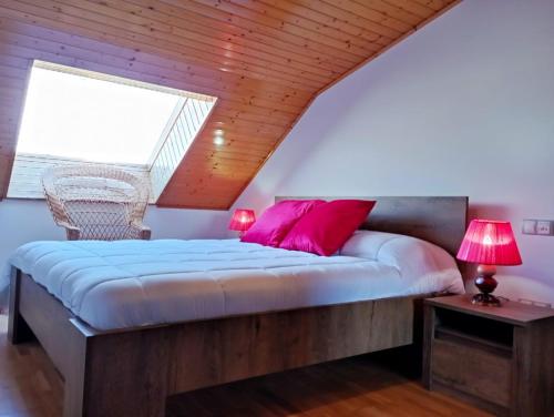 a bedroom with a large bed with pink pillows at Apartamento, Ático, Casa, PLAYA LAS CATEDRALES in San Cosme de Barreiros