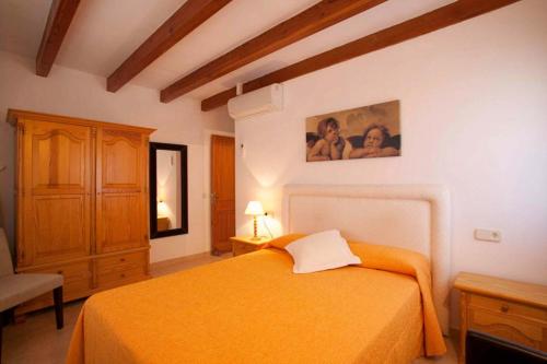 a bedroom with a orange bed and a dresser at Serelleta in Pollença