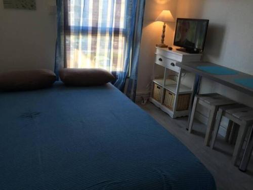 une chambre avec un lit, un bureau et une télévision dans l'établissement Abis Cap corniche sejour cocooning dans un coin de paradis, à Sète