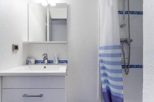 une salle de bain blanche avec un lavabo et un miroir dans l'établissement Abis Cap corniche sejour cocooning dans un coin de paradis, à Sète