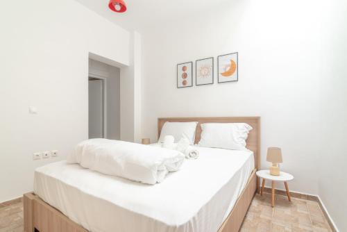 een witte slaapkamer met een groot bed met witte lakens bij 1 BedRoom Apartment Opposite Medical Center in Heraklion