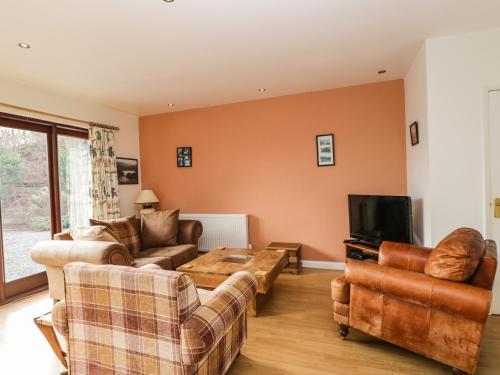 a living room with two couches and a tv at The Lodge in Merthyr Tydfil