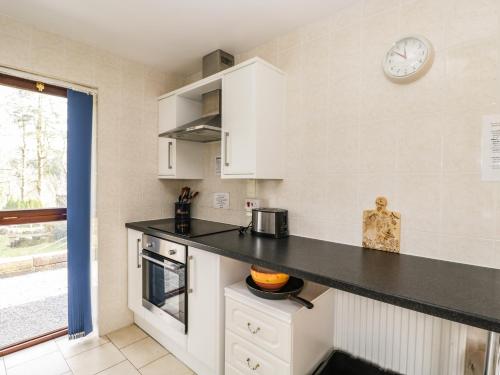 a kitchen with a counter and a clock on the wall at The Lodge in Merthyr Tydfil