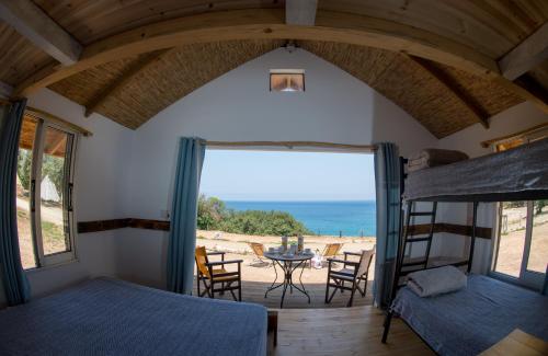 a bedroom with bunk beds and a view of the ocean at Aphrodite Family Eco Camping in Neo Chorio