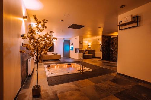 - un salon avec une baignoire au milieu d'une pièce dans l'établissement Maas en Waal Wellness & Suites, à Dreumel