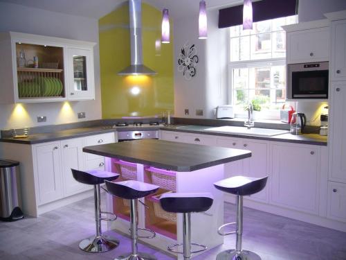 a kitchen with a island with purple bar stools at Stylish & Contemporary 5 * Fully Renovated Luxurious Holiday Cottage Ambleside in Ambleside