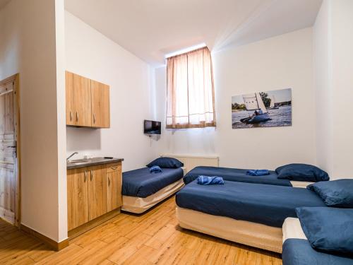 a bedroom with two beds and a sink in it at SSW Grand Hostel Iława in Iława