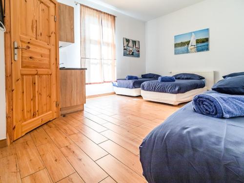 een slaapkamer met 2 bedden en een houten vloer bij SSW Grand Hostel Iława in Iława