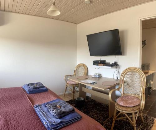 a bedroom with a bed and a desk with a tv at Falster værelse in Væggerløse