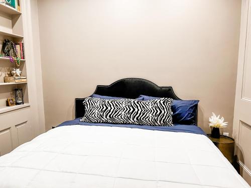 
a bed in a bedroom with a white bedspread at Bon Maison Guest House in New Orleans
