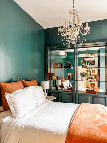 a bedroom with green walls and a bed with a chandelier at Bon Maison Guest House in New Orleans
