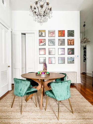 a dining room with a wooden table and green chairs at Bon Maison Guest House in New Orleans
