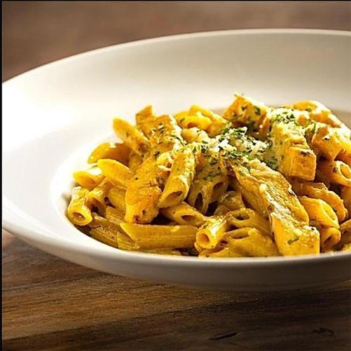 a white bowl of pasta with chicken and cheese at The Iona Heights Inn in Iona