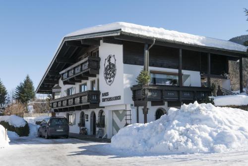 a building with a pile of snow in front of it at Alpenresidenz Unterrainer in Ellmau