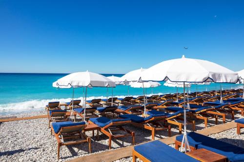 
a beach area with chairs and umbrellas at Hotel Beau Rivage in Nice
