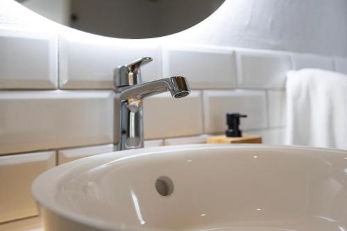 a bathroom sink with a faucet and a mirror at Pomar das Oliveiras - Private Swimming pool - Free EV Chrg - Pet Friendly in Carvalhal Cimeiro