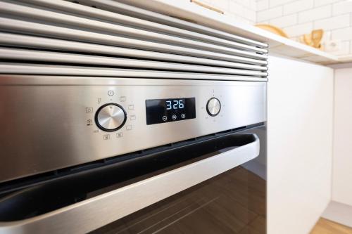 a kitchen with an oven with a clock on it at Pomar das Oliveiras - Private Swimming pool - Free EV Chrg - Pet Friendly in Carvalhal Cimeiro