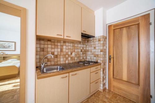 een keuken met houten kasten en een wastafel bij Residence Pichler Apartment 2 in San Leonardo in Passiria