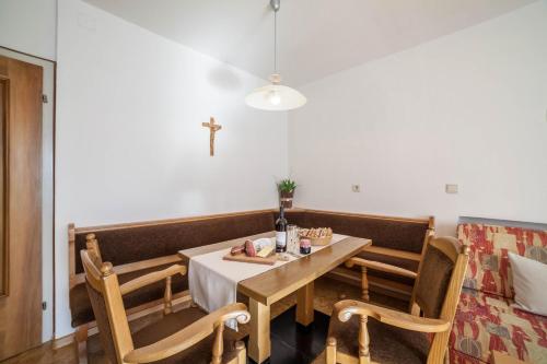 a dining room with a table and a cross on the wall at Residence Pichler Apartment 2 in San Leonardo in Passiria