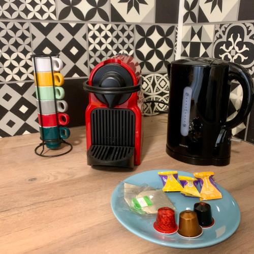 a table with a plate of food next to a coffee maker at Le Golf Balnéo - Cosy & SPA - Appartement in Saint-Étienne