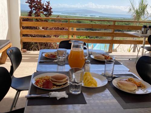 a table with plates of breakfast food and orange juice at Altos de la Caobita in Barreras