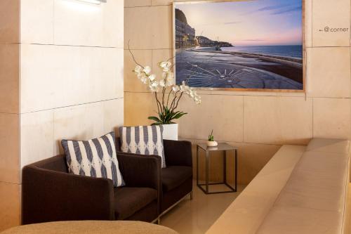 a living room with two chairs and a painting on the wall at Hotel Beau Rivage in Nice