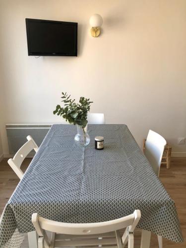 - une table à manger avec un vase et une plante dans l'établissement Charmant T2, hyper-centre, à 50m de la plage !, à Le Touquet-Paris-Plage