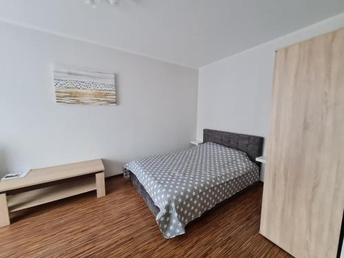 a small bedroom with a bed and a table at Central station in Daugavpils