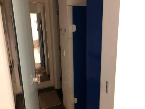 a hallway with a blue door and a mirror at iHOSTEL ALDEOTA in Fortaleza