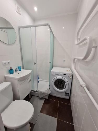 a bathroom with a toilet and a washing machine at Central station in Daugavpils