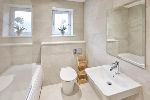 a bathroom with a sink and a toilet and a mirror at Host & Stay - 3 Queens Court in Whitley Bay