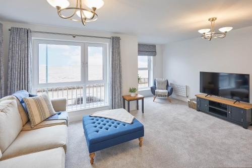 a living room with a couch and a tv at Host & Stay - 3 Queens Court in Whitley Bay