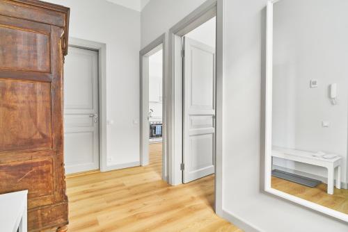 pasillo con 2 espejos y puerta de madera en New and Lovely Apartament in Vilnius City Centre en Vilna