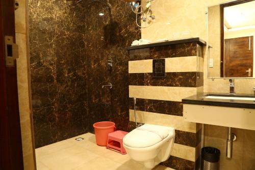 a bathroom with a toilet and a sink and a shower at Hotel Kush Ganga - 50 Meter from Har ki Pauri, Haridwar in Haridwār