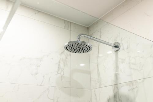 a shower with a shower head in a bathroom at Causeway Coast Beach Front Apartment - Ballycastle in Ballycastle