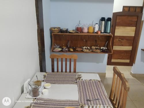 a table with two chairs and a table and a shelf with shoes at Chalés do Apolinário in Tiradentes